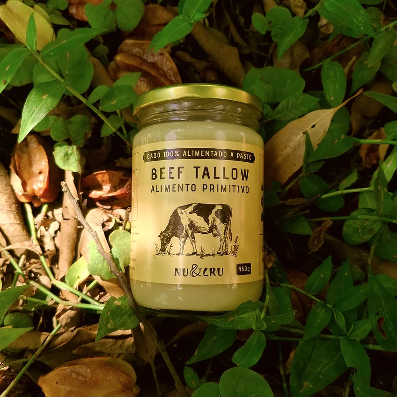 Pote de vidro de Beef Tallow Nu&Cru entre folhas