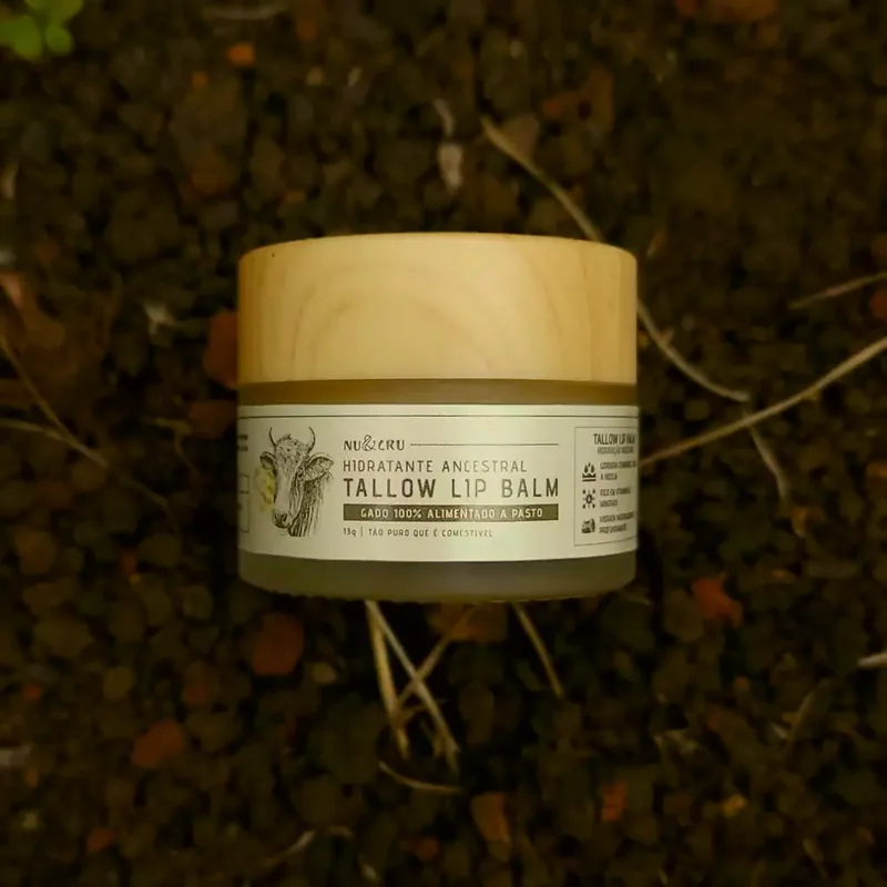 Pote de Tallow Lip Balm Nu&Cru sobre a terra