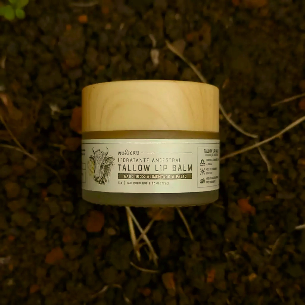 Pote de Tallow Lip Balm Nu&Cru sobre terra escura